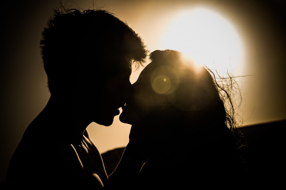 Deux jeunes gens qui s'embrassent devant l'aurore 